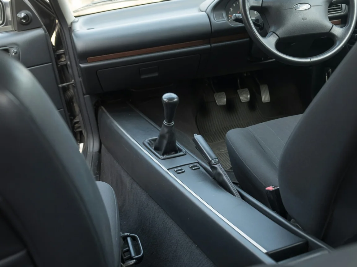 Manual gearshift and three pedals inside a Ford passenger car