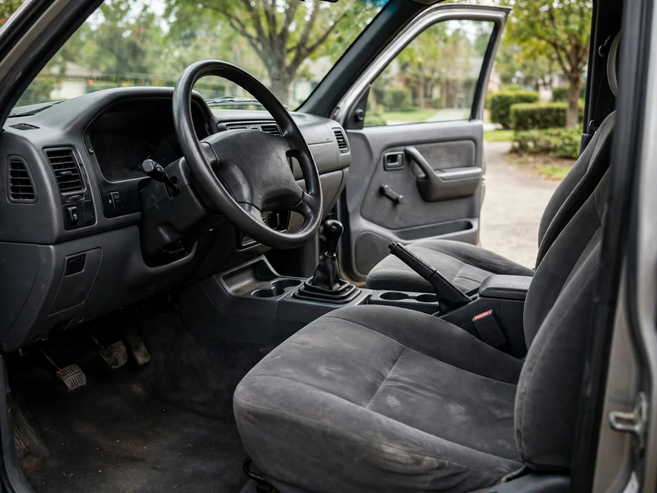 Pickup truck interior showing a manual gearshift, clutch pedal and steering wheel