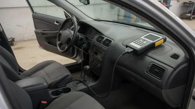 Diagnostic scan tool beside a vehicle dashboard during a P1745 fault investigation
