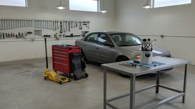 Jeep parked in a service bay with a fuel pump module on a nearby workbench