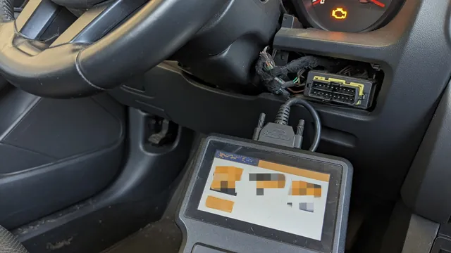 OBD-II scan tool plugged into a car's diagnostic port while the check engine light is on