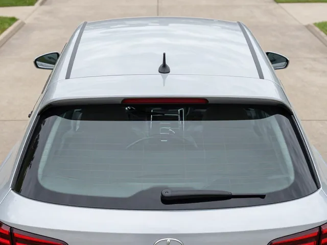 Rear wiper blade and attachment on a parked hatchback with the rear glass visible