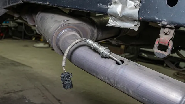 Ram 1500 exhaust oxygen sensor with its wiring connector visible on a cooled exhaust pipe