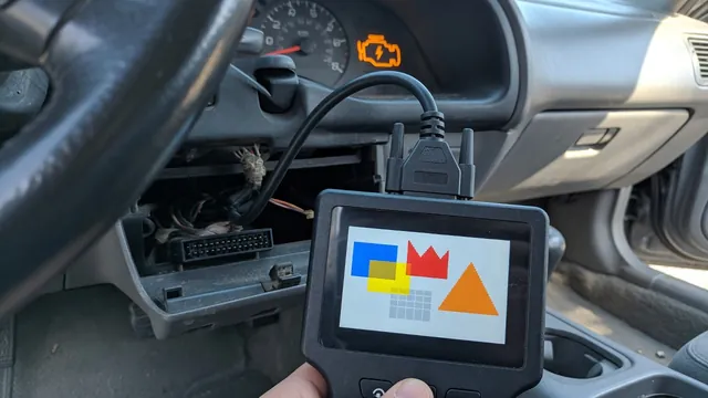 OBD-II scan tool connected under a car dashboard with the check engine light on