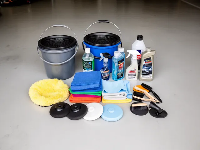 Car detailing supplies laid out on a garage floor including buckets, microfiber towels, spray bottles, shampoo, applicator pads and brushes