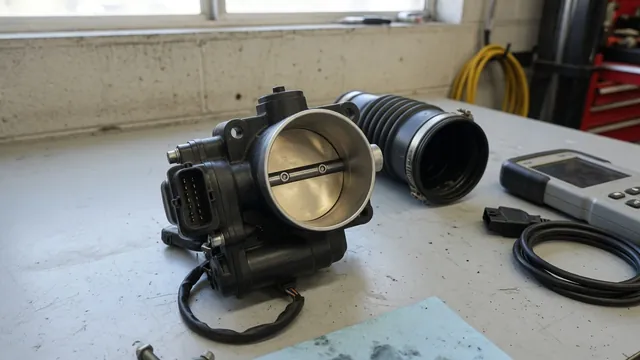 Electronic throttle body on a clean workbench beside an intake duct and diagnostic scan tool