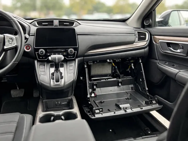 Honda CR-V passenger glove box open with the cabin air filter access area visible