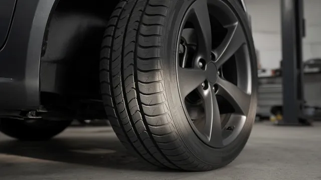 Close-up of a car tire with patchy, cupped tread wear that can come from a worn wheel bearing