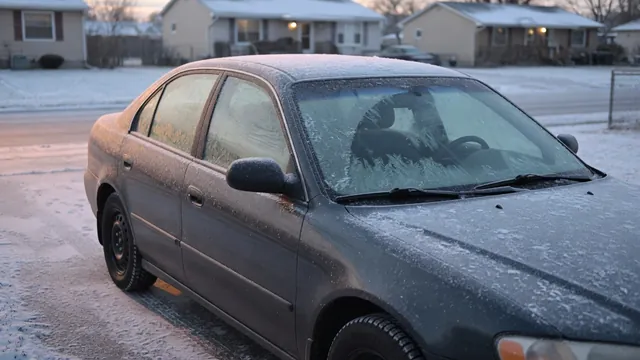 Snow-covered gasoline car parked outdoors on a cold morning with frost across its windshield.