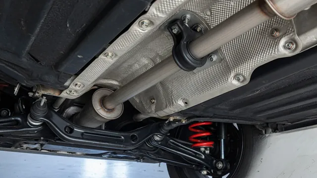 Illustration of an underbody heat shield, exhaust hanger and suspension near a rear wheel