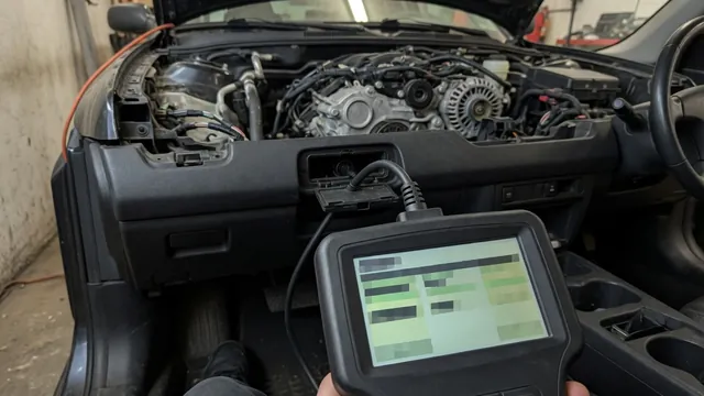 OBD-II scan tool showing a cam/crank correlation trouble code, with an engine's timing cover area in the background