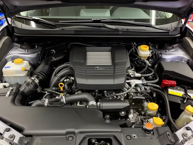 Coolant reservoir and radiator area in a Subaru engine bay with the engine off and cool