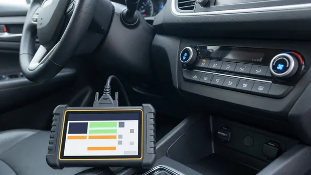 Car climate control panel with a lit A/C button and an OBD-II scan tool plugged in under the dashboard