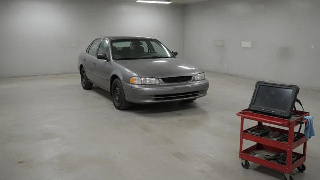 Diagnostic scan tool beside a vehicle with the right front wheel and brake assembly visible