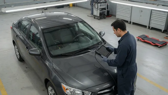 Technician reviewing transmission fault codes on a scan tool beside a parked vehicle