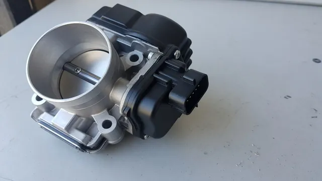 Illustration of an electronic throttle body with its electrical connector and throttle plate visible