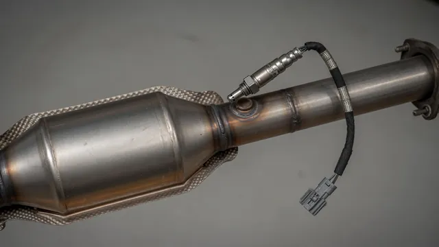 Illustration of a downstream oxygen sensor and its electrical connector near a catalytic converter