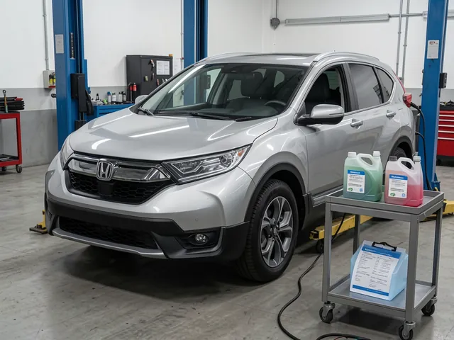 Honda CR-V parked in a clean service bay with sealed transmission fluid containers on a nearby cart