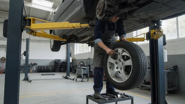 Technician inspecting a car tire and wheel hub on a shop lift for a humming noise