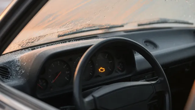Car dashboard showing a low temperature gauge reading and a lit check engine light on a cold morning