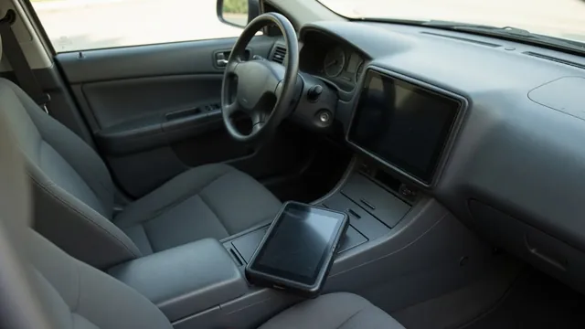 Vehicle infotainment screen with no display and a diagnostic scanner resting on the center console