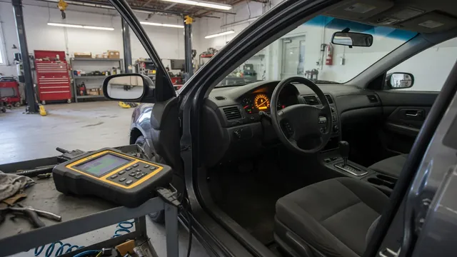Diagnostic scanner beside a vehicle dashboard with a warning light illuminated
