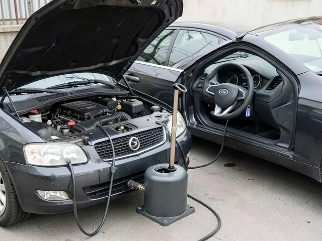 Oil extractor reservoir beside an engine bay with a suction tube routed into the dipstick opening