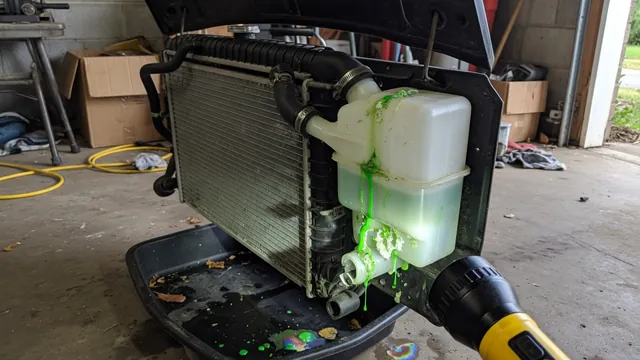 Car radiator with coolant residue along the plastic tank seam, lit by a flashlight during a leak inspection