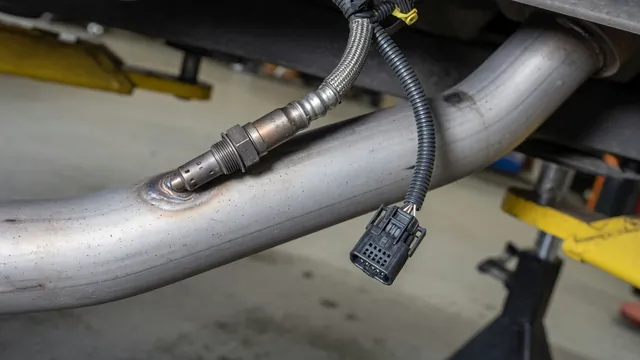 Oxygen sensor with its electrical connector and heater wiring beside a cool exhaust pipe