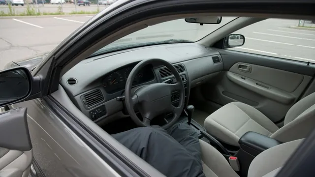Driver checking a dashboard warning while safely parked with the driver’s door open.