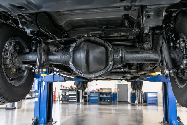 Vehicle rear differential housing and axle assembly viewed in a clean automotive service bay