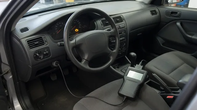 Dashboard with an illuminated check engine light and a diagnostic scanner beside the steering wheel