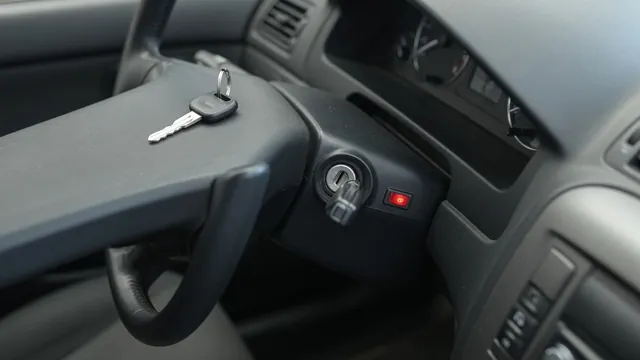 Vehicle key beside an ignition switch with a security indicator visible on the dashboard