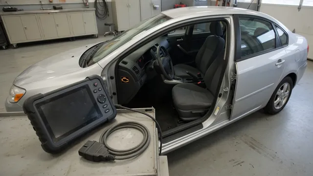 Diagnostic scan tool beside a vehicle with a chassis warning displayed on the dashboard