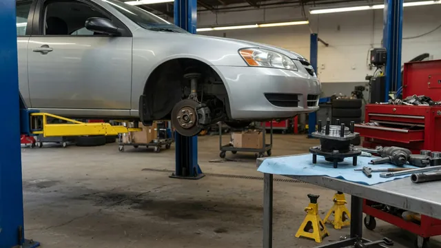 Subaru Outback wheel hub area with a replacement wheel bearing assembly on a nearby workbench