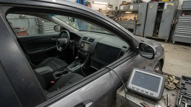 Diagnostic scanner beside a vehicle dashboard during a body control system inspection