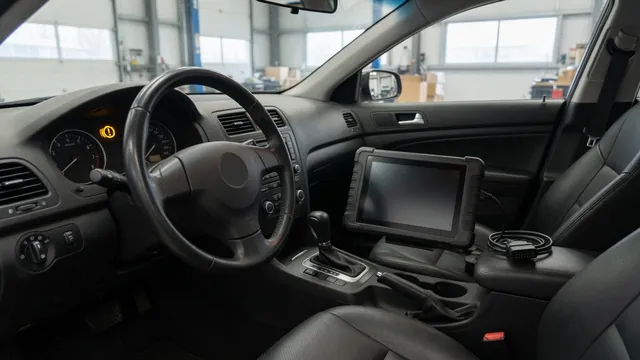 Diagnostic scanner beside a vehicle instrument cluster showing a transmission warning