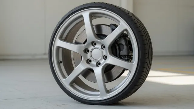 Close-up of a car’s disc brake rotor and caliper visible through an alloy wheel