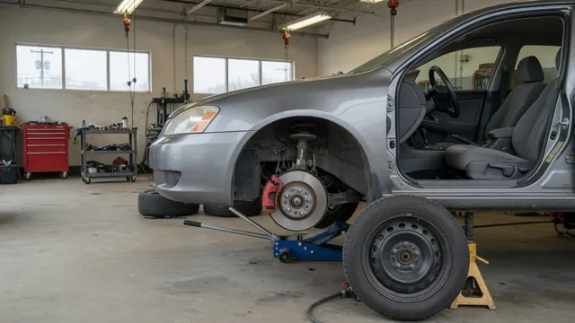 Close-up of a brake rotor, caliper, and wheel hub on a stationary vehicle in a repair shop