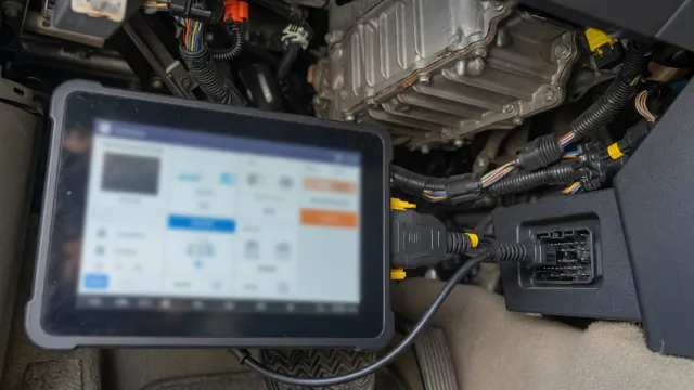 Scan tool plugged into a vehicle's diagnostic port, with the transfer case wiring shown in the background