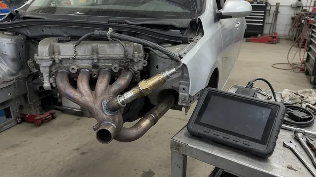 Illustration of an upstream oxygen sensor in an exhaust manifold with a diagnostic scanner nearby
