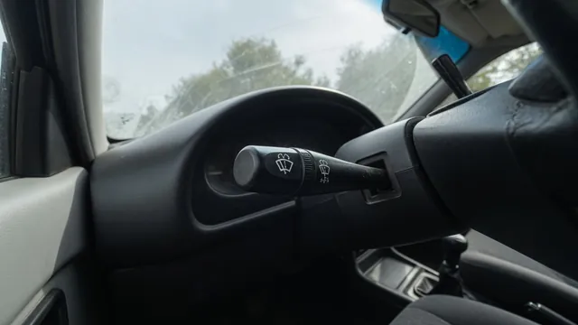 Close-up of a steering-column wiper control stalk with wipe and washer symbols