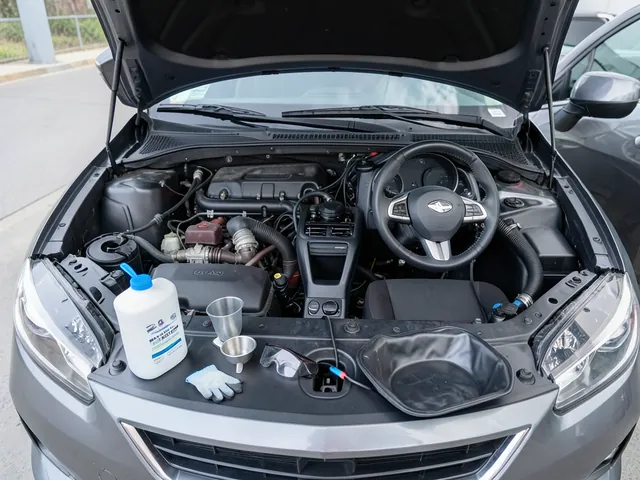 Coolant replacement supplies arranged beside a parked car with its engine off and hood open