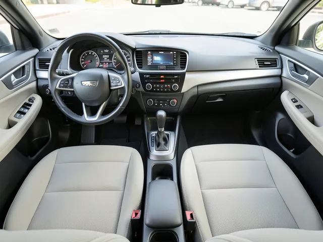 Manual gear shifter and three pedals inside a parked four-door car