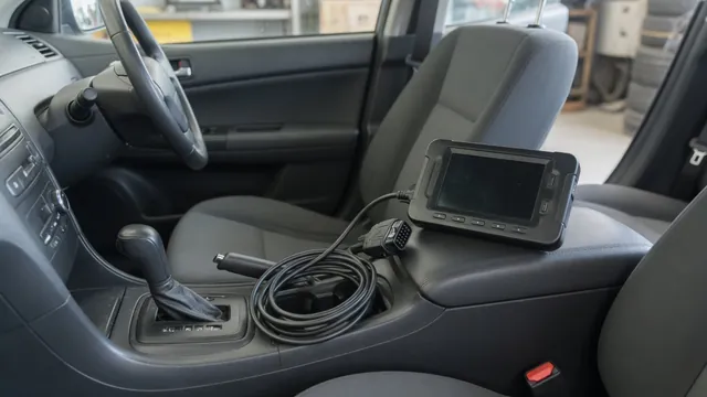 Diagnostic scanner beside a vehicle gear selector during a parked inspection