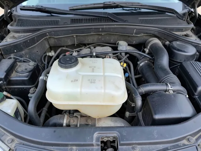 Coolant reservoir with minimum and maximum level marks visible in an engine bay
