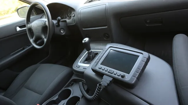 Diagnostic scan tool beside a vehicle center console with the gear selector visible