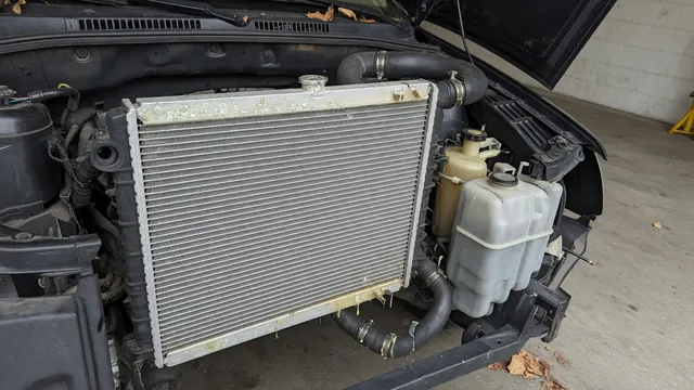 Radiator with visible fin corrosion and dried coolant residue near a tank seam