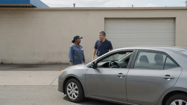 Driver beside a parked car describing starting trouble to an automotive technician