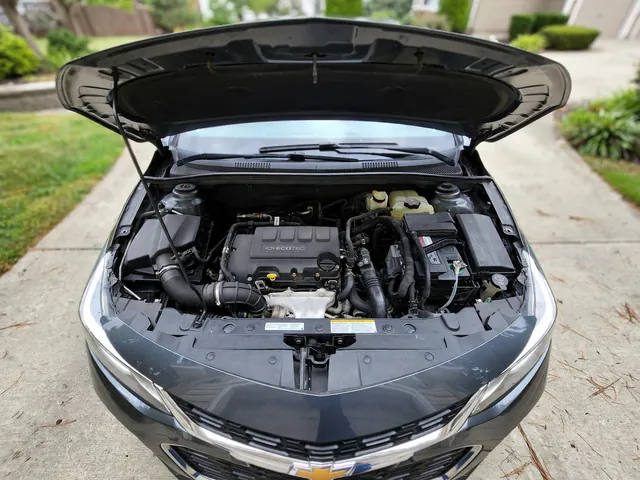 Coolant reservoir in a Chevrolet Cruze engine bay with the engine off and cool